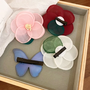 Lace butterfly and floral hair clips in assorted colors on a grey display tray