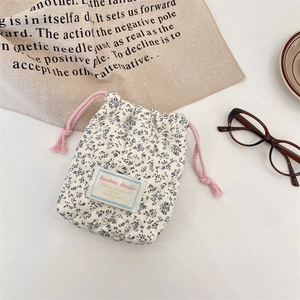 Floral quilted cotton drawstring storage bag for compact cameras in a lifestyle setting