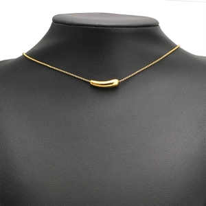 Minimalist gold stainless steel necklace with curved tube pendant on a black bust
