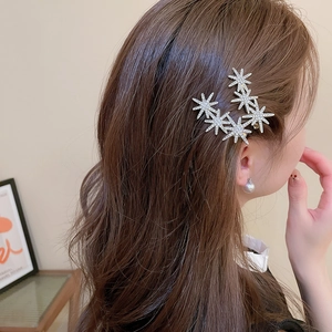 Detailed view of shimmering star-shaped rhinestone hair clip worn by a model