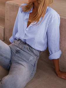 Detail showing vertical light blue and white stripes on a long sleeve casual shirt button-up