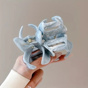 Detailed close-up of blue marble-pattern flower hair claw clip with durable metal spring