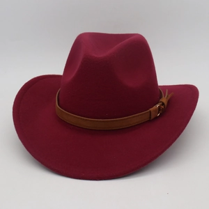 Detail of burgundy wool cowboy hat with brown leather belt and golden metal buckle