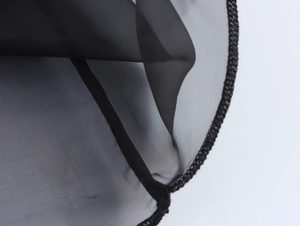Détail du tissu en organza noir transparent montrant la texture des mailles et la finition
