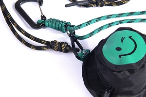 Dettaglio della mini borsa a secchiello con cordino intrecciato verde e moschettone
