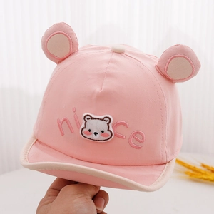 Detail einer rosa Baby-Kappe mit Bären-Aufnäher, Stickerei und süßen kleinen Bärenohren