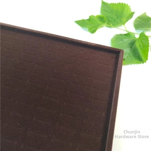 Close-up of deep brown velvet jewelry display tray with slots for 100 rings and studs