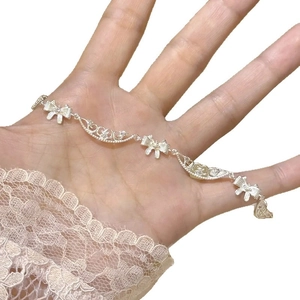 Bracelet nœud en argent avec maillons en dentelle évidée et zircons sur fond blanc