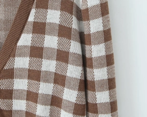 Close-up of checkerboard knit cardigan showing shoulder stitching and V-neck details