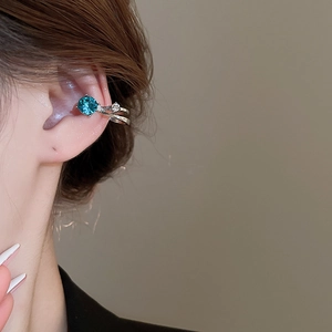 Vue macro d'un earcuff argenté à double couche avec une pierre précieuse bleu foncé