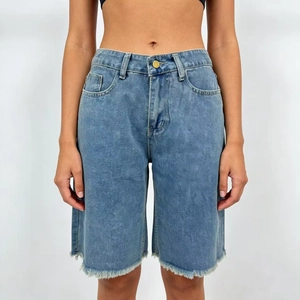 Detail of high-waisted denim shorts in light wash blue with raw hem and woven texture