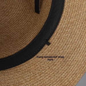 Detail view of the straw hat inner band showing a small loop for a windproof chin strap