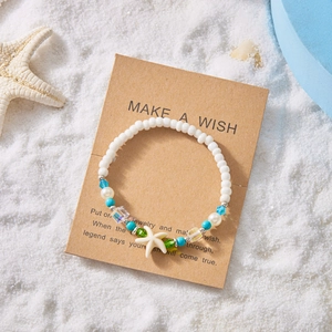 Summer beach starfish beaded bracelet on a kraft card with ocean-themed sandy background