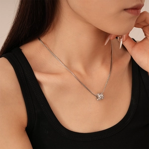 Primo piano di una collana multistrato argento con un ciondolo di strass luccicante su modella