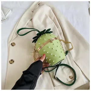 Détail du sac seau fraise vert clair avec perles blanches et cadre en métal doré