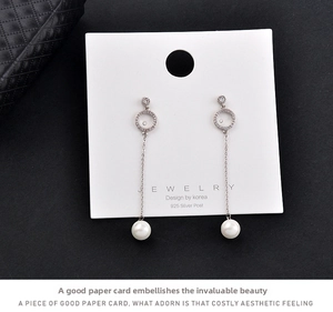 Close-up of pearl drop earrings with S925 silver posts on a white display card