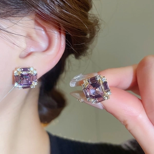 Close-up of square purple zircon stud earrings with micro-paved diamond halo setting