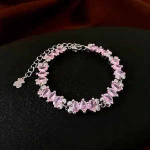 Elegant silver bracelet featuring oval pink cubic zirconia and a cute bear charm pendant