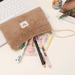 Close-up of brown plush cosmetic bag with bear patch and lamb wool texture