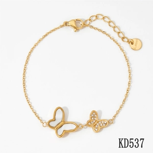 Detailed macro of gold stainless steel butterfly charm bracelet with sparkling zircons