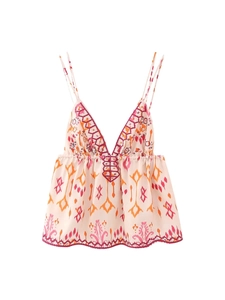 Détail de la broderie à paillettes et des motifs ethniques sur un crop top col V