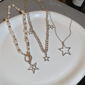 Detail of multi-layered silver star necklaces with pearls and toggle clasp on a tray