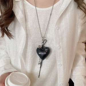 Detail of black leather heart pendant with bow on a silver ball chain necklace