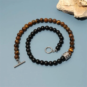 Detail of beaded necklace with tiger eye and black onyx stones featuring a toggle clasp