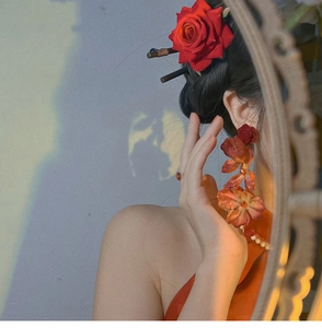 Detail of red rose hair pin and long floral tassel earrings with pearl accents