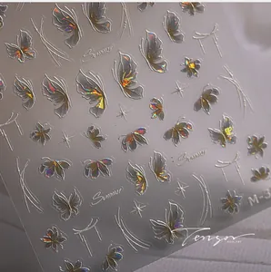 Detail of holographic laser butterfly nail stickers with 3D embossed texture on grey background
