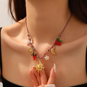 Bohemian colorful woven rope necklace with sun, cherry, and star charms worn by a model