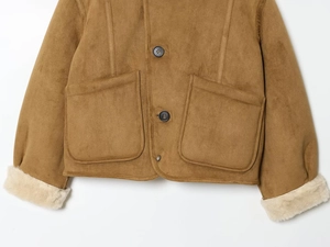 Detail der braunen Wildlederjacke mit weichen cremeweißen Sherpa-Manschetten und Textur