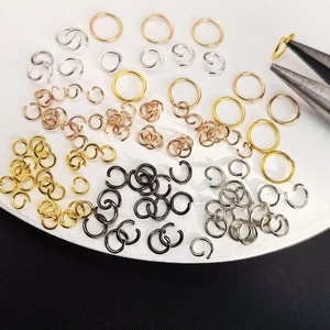 Assorted DIY jewelry jump rings in various metal finishes on a white base plate