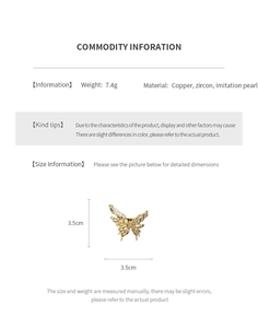 Macro detail of gold plated butterfly ring with white pearls and cubic zirconia stones