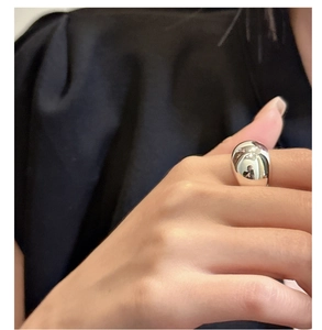 Dettaglio di un anello minimalista in argento S925 con un design lucido a ciottolo