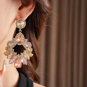 Gros plan détaillé de boucles d'oreilles vintage en cristal champagne portées par modèle