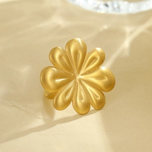 Macro shot of 3D golden flower ring with matte brushed finish and artistic lighting effects