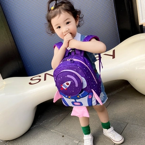 Outdoor shot of a toddler wearing a purple 3D rocket backpack with space design and wings