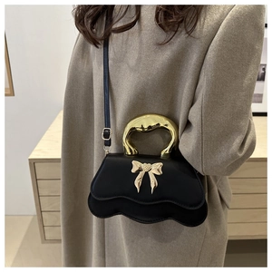 Black wavy crossbody bag with gold bow decoration and metallic handle for women