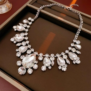 Close-up of teardrop crystal necklace with lobster clasp and extension chain on a tray