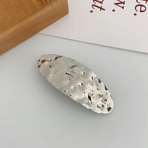 Detail shot of silver metal hair clip with unique irregular hammered texture finish