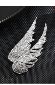 Macro shot of silver-colored angel wings brooch with sparkling pavé cubic zirconia