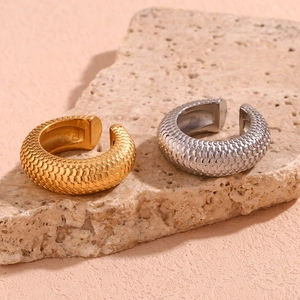 Detailed macro view of 18K gold and silver steel C-shaped cuffs with scale texture