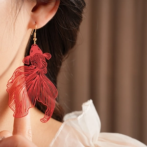 Gros plan d'une boucle d'oreille carpe koi rouge sur un modèle, style chinois moderne
