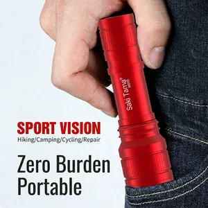 Portable mini LED flashlight in red metal finish being placed in a pocket for outdoor use