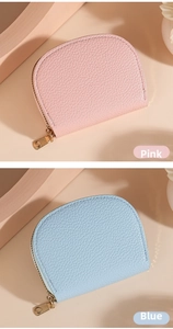 Detail of pink and blue lychee grain leather shell-shaped wallets with gold zippers