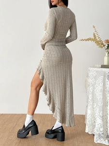 Detail of light grey ribbed knit dress featuring unique asymmetric ruffle hemline