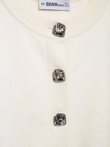 Detail of cream knit cardigan featuring unique irregular silver textured metal buttons