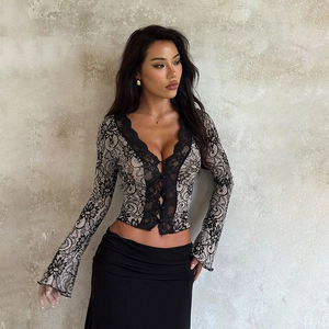 Detail of elegant black and beige floral lace texture on a slim-fit V-neck long sleeve top