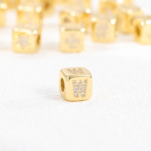 Detailed macro of 18k gold plated cube bead featuring a zircon-studded W letter